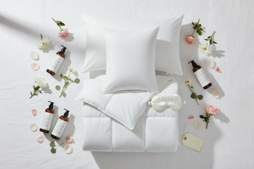 Luxury hotel quality gift flat lay featuring Westin soft and firm hotel pillows, IHG down alternative duvet insert, Le Labo Rose 31 bath set, and luxury hotel
