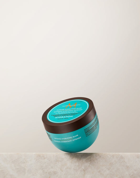 Turquoise Moroccanoil Intense Hydrating Mask 250 ml jar with dark brown lid on a light stone ledge