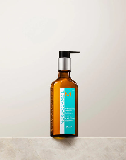 Moroccanoil Treatment Light 100 mL in an amber bottle with a turquoise Light label, shown with a black pump dispenser.