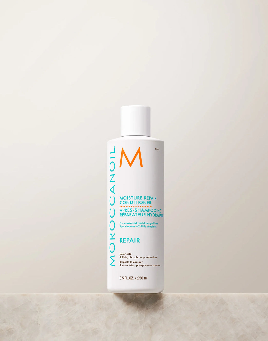 Front view of the white 250 mL Moroccanoil Moisture Repair Conditioner bottle with turquoise lettering, shown on a light stone surface.
