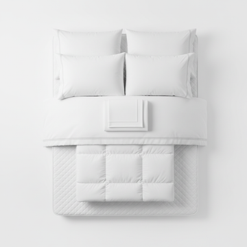 IHG hotel bed bundle for queen featuring white pillows, sheets, duvet, and quilted mattress pad.