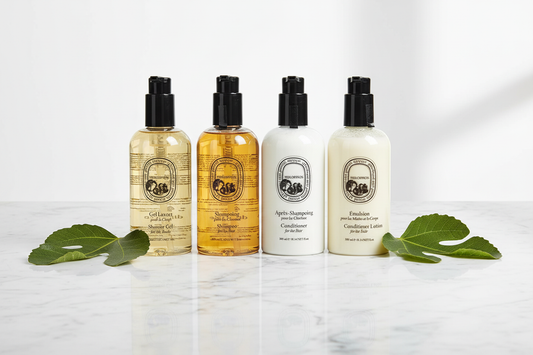 Diptyque Philosykos Conditioner and hair care products on marble surface with fig leaves.