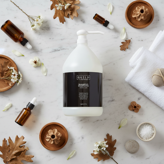 Guild+Pepper Shampoo 1 Gallon - bulk hotel shampoo on marble flat lay with warm oak elements