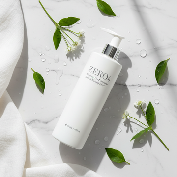 Zero% Naturally Kind Shampoo flat lay with botanicals on white marble