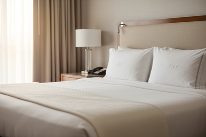 Westin Heavenly Bed king pillows arranged on a neatly made king-size bed in a stylish hotel room.